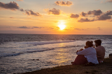 Fototapeta premium Sunset View with Orange and Pink Sky Reflecting Over the Landscape with People Relaxing