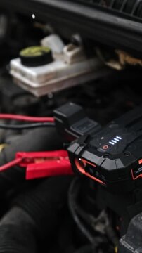 Connecting Portable Jump Starter Battery Device To Engine With Low Battery, Vertical Video
