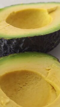 Cutting open an avocado to prepare it for eating. vertical video.