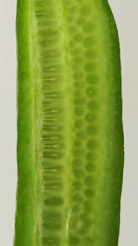 Cucumber is cut to reveal its texture and seeds. vertical video.