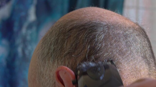Man cuts hair at home in mirror