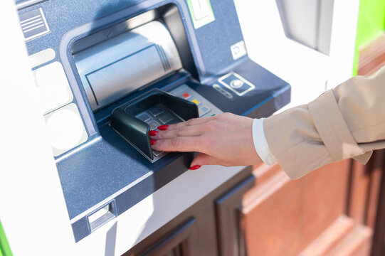 Woman entering secret banking pin on atm keypad