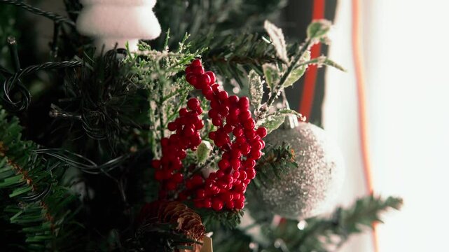 Person decorating christmas tree with red berries