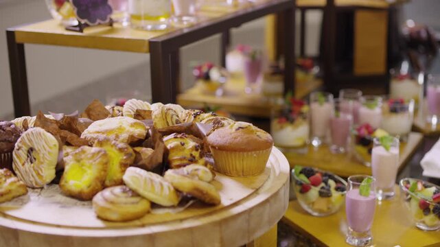 Baked treats are displayed on a platter thats surrounded by fruity smoothies and fruit bowls.