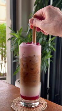 Stirring a Raspberry Ice Latte Coffee