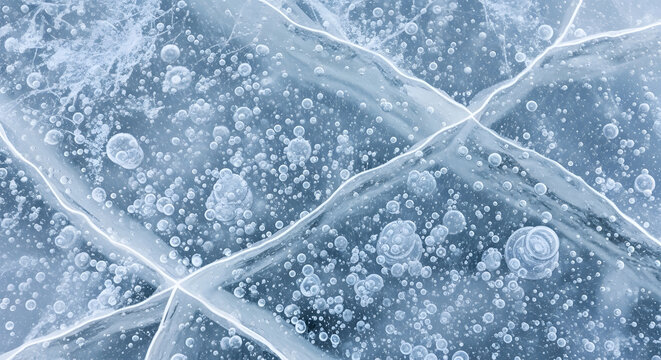 Close-up of cracked ice surface with trapped air bubbles in winter texture