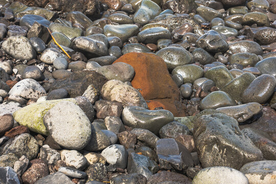Rocky shoreline pebbles with rust volcanic stone, Madeira coast