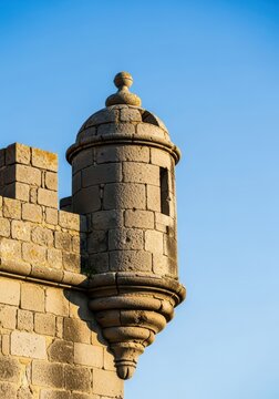 Close up view of the distinctive castellated parapet wall of an ancient fortress tower built with rugged stone blocks, exterior, crenellated, historic