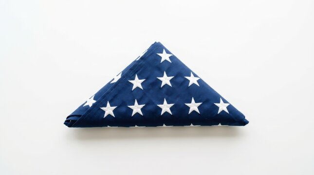 Neatly folded American flag displaying its blue field and white stars on a clean white background
