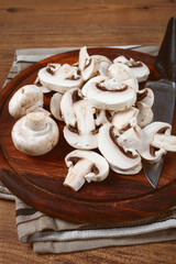 Fototapeta premium fresh mushrooms, chopped, in a wooden bowl, whole, top view, no people,