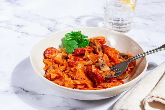 Bigos, Polish dish bigos, on a marble table, stewed meat with cabbage, chorizo sausages, mushrooms, homemade, without people,