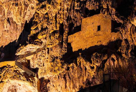 Cotignac, Provence-Alpes-C&ocirc;te d&rsquo;Azur, France, 3 April 2026: troglodyte dwellings carved into cliff with illuminated stairs at night, historic rock architecture in southern France