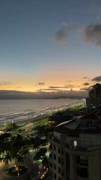 Modern seaside skyline with high-rise buildings and sunset over the ocean in Brazil called Rio de Janeiro Barra Tijuca neighborhood look down camera extreme long shot