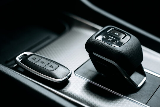 Close up of gear shift and car keys in modern car interior. Automotive technology concept.
