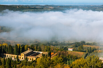 Obraz premium Fog rolling through valley with buildings in Montepulciano, Italy.