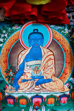 Vibrant Tibetan thangka painting of blue Medicine Buddha seated in lotus position with offerings.