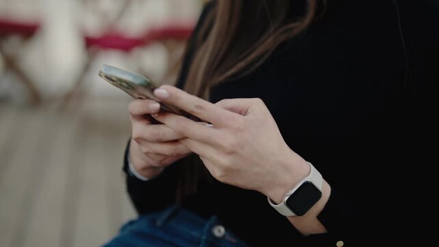 Close-up of a woman's hands using a smartphone and wearing a smartwatch, focusing on connectivity, technology, and communication. Woman Using Smartphone and Smartwatch