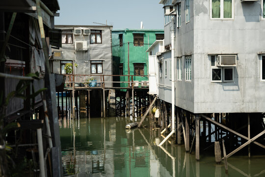 Inhabited pang uk stilt houses reflected in the tidal channel of Tai O fishing village, Lantau Island, Hong Kong