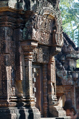 Obraz premium Pink sandstone sanctuaries of Banteay Srei rise above the courtyard, their surfaces covered with elaborate mythological reliefs. Siem Reap. Cambodia.