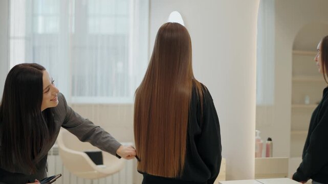 A hair stylist consults with a client about her long, straight hair in a modern salon. They discuss style options, and the stylist examines the client's hair. Modern Beauty Salon