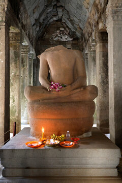 Large headless Buddha statue at Ta Prohm temple.  Siem Reap. Cambodia.