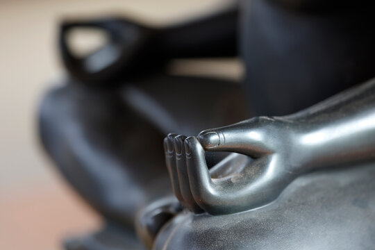 A polished dark metal Buddha hand performs the vitarka mudra, symbolizing the transmission of Buddhist dharma teachings.  Siem Reap. Cambodia.