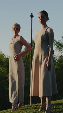 Two women posing outdoors in elegant beige dresses during sunset. The atmosphere is serene and stylish, emphasizing fashion and grace. Elegant Women Posing Outdoors in Stylish Dresses