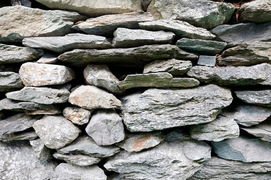 Traditional dry-stone masonry wall showcasing natural alpine granite and schist textures in close detail. Saint Gervais.  France.