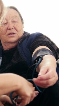 Two senior ladies - senior women checking healthcare state with manometer - measures pressure, elderly lifestyle