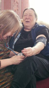 Two pensioners - senior ladies have fun - checking health state with manometer - measures pressure, pensioners healthcare