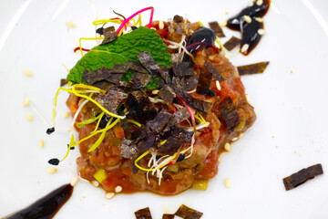  Asian kitchen. Gourmet beef tartare topped with crispy seaweed, mint leaf and sesame garnish. © Godong Photo