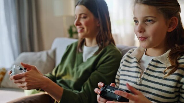 Sisters hands pressing joysticks playing video game sofa closeup. Upset family