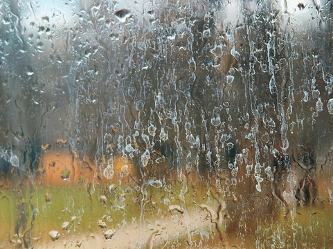 Raindrops on the dirty window glass surface background