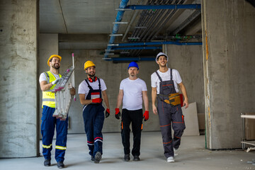 Fototapeta premium Workers Carrying Stepladder and Walking Through Building Site
