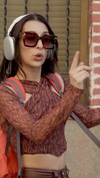 Happy young woman dancing listening to music on headphones outdoors