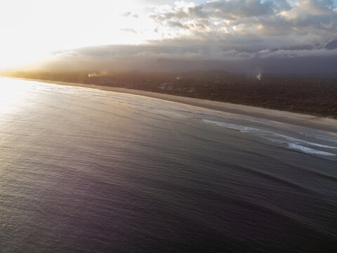 Aerial wide view of Bora Bora beach in Boraceia at sunset with people walking on wet sand mirror in Brazil