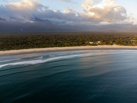 Aerial wide view of Bora Bora beach in Boraceia at sunset with people walking on wet sand mirror in Brazil