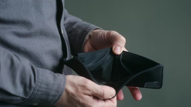 Man hands opening empty black wallet, revealing he has no cash, symbolizing poverty, financial crisis, debt, unemployment, economic problems of bankruptcy. Man showing empty wallet with no money