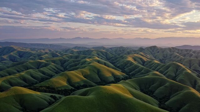 Breathtaking aerial view of rolling green hills at sunset. Natural landscape showcases vibrant colors and serene atmosphere. Perfect for nature enthusiasts and travel lovers.