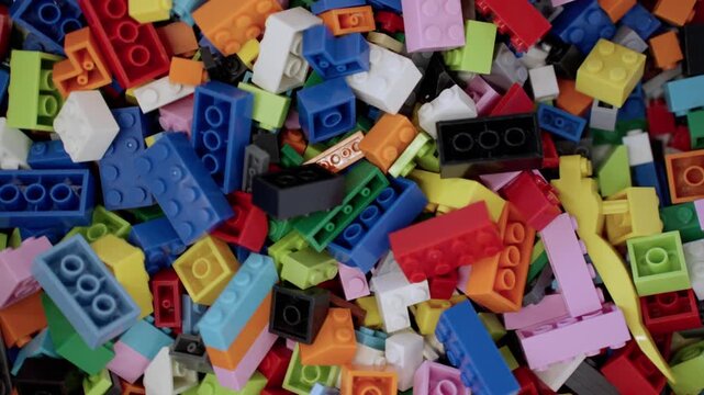 Pile of child building blocks in multiple colours. Top view. Slow motion. Educational gaming center