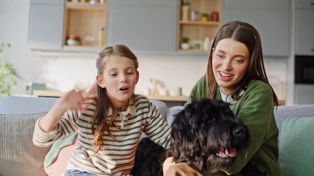 Closeup family greeting tablet embracing dog at couch. Aunt niece waving hands