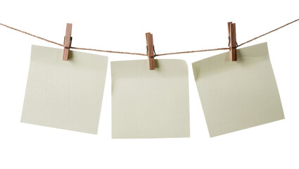 Isolated three empty light yellow square memo notes hanging on a clothesline with wooden pins. © Iura