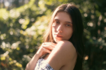 Naklejka premium Soft portrait of young woman in warm woodland light