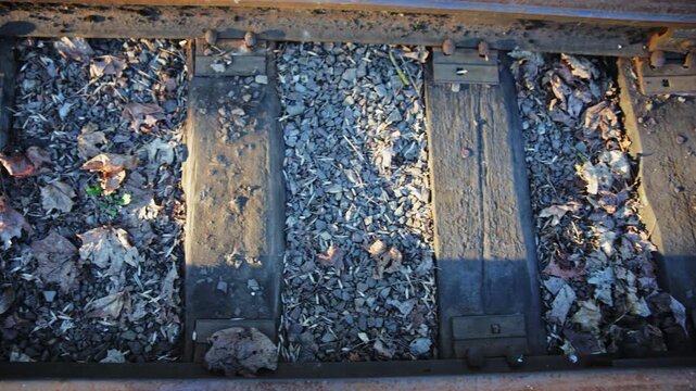Close-up of Old Wooden Railway Sleepers and Steel Rails with Gravel