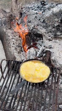 provoleta cocinandose a la sart&eacute;n de hierro fundida en la parrilla