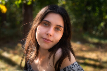 Naklejka premium Soft portrait of young woman in natural forest light