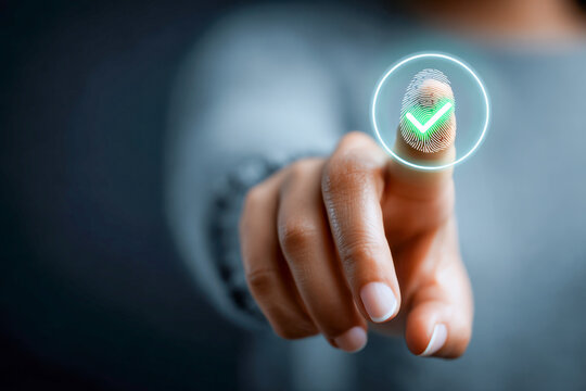 Person using fingerprint recognition technology with a glowing verification symbol to access secure digital information or authenticate identity on a touchscreen dev