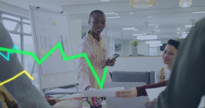 Designer using tablet, taking pen, leading design review while animated graphs sliding over team