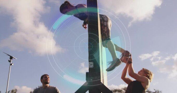 Vertical video: Climbing woman in top at park, mate holding feet on post, vaulting and landing, HUD