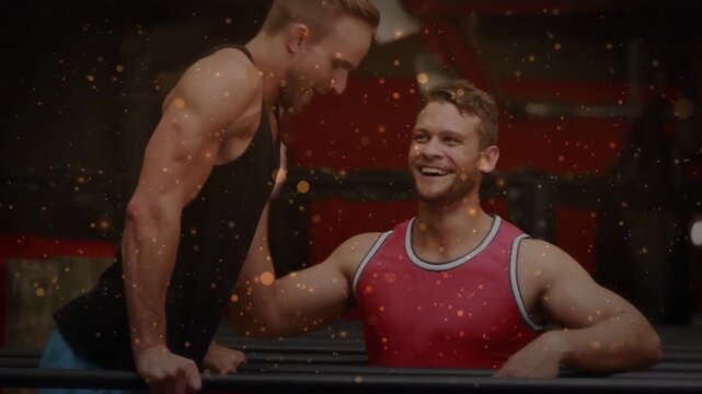 Vertical video: Lifter starting L-sit on bars spotter aiding legs for gym core sparks floating over